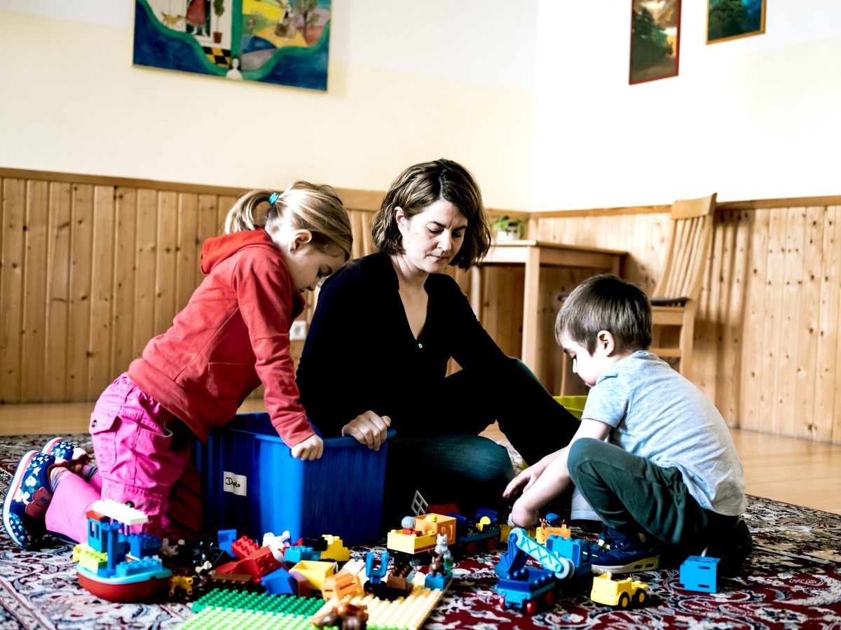 Ein Mutter mit ihren beiden Kindern bei gemeinsamen spielen